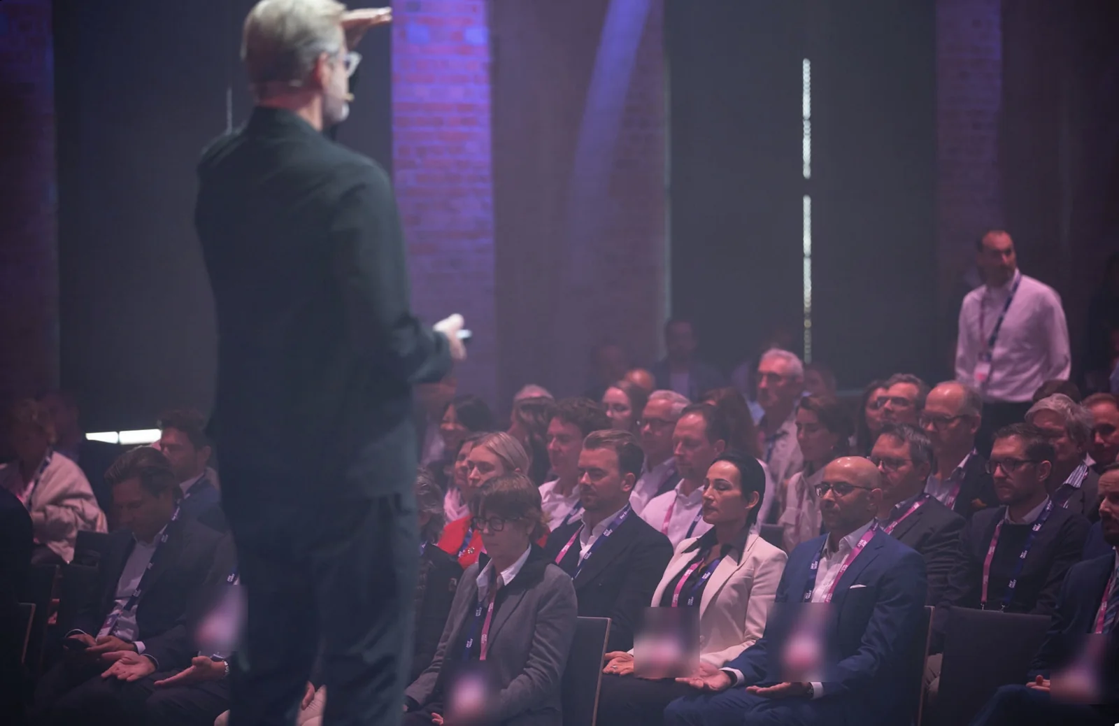 Participants at MY WAY 2026 sit with eyes closed and open hands while Achim Feige guides the practice from the stage